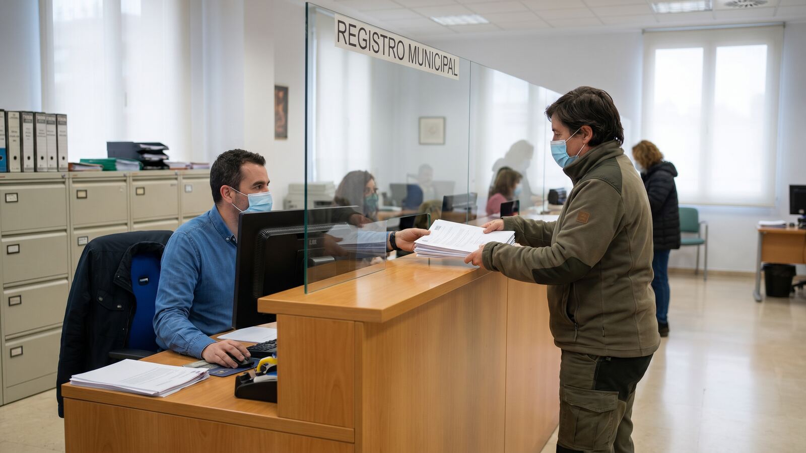 Trámite de cita de empadronamiento en un ayuntamiento español, persona gestionando documentación oficial